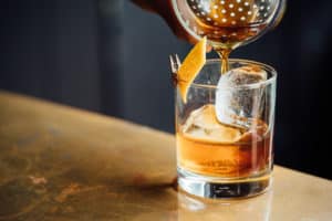 Drink being poured into a highball glass