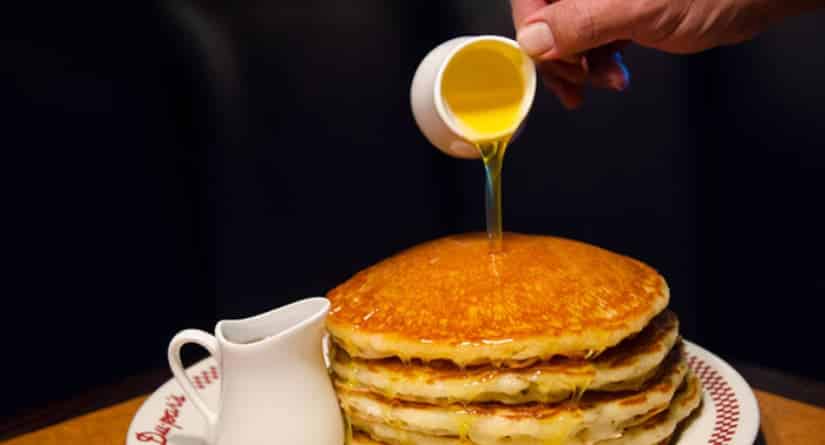 Stack of Du-Pars pancakes with syrup being poured onto them