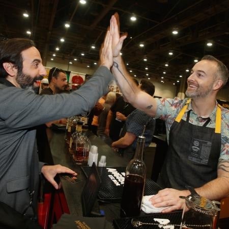 An attendee and exhibitor high-fiving at a previous BAR-Restaurant Expo. 