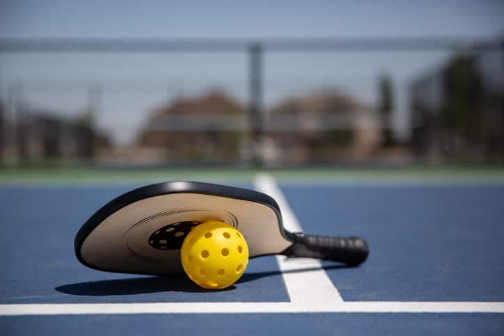 A Pickleball paddle and ball. 