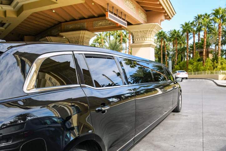 Black limousine parked outside a Las Vegas hotel, showcasing luxury transport options in the city.