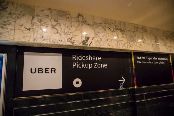 Sign for Uber Rideshare Pickup Zone in a marble hall, showing transportation options in Las Vegas.