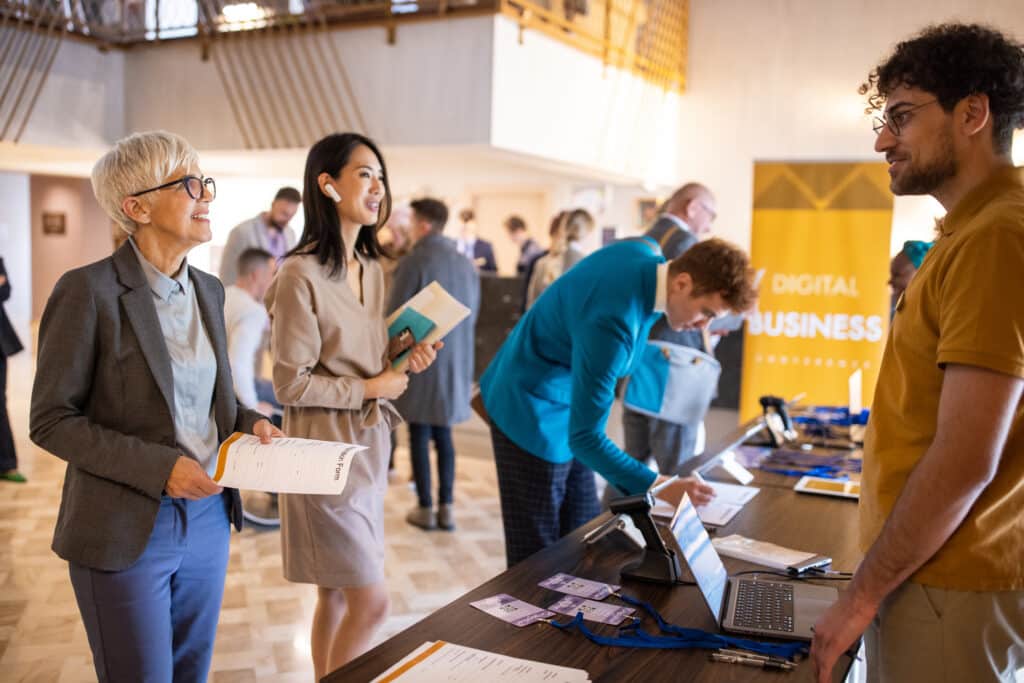 A Group Of Business Conference Participants Registering For A Conference In The Lobby Of A Luxury Hotel