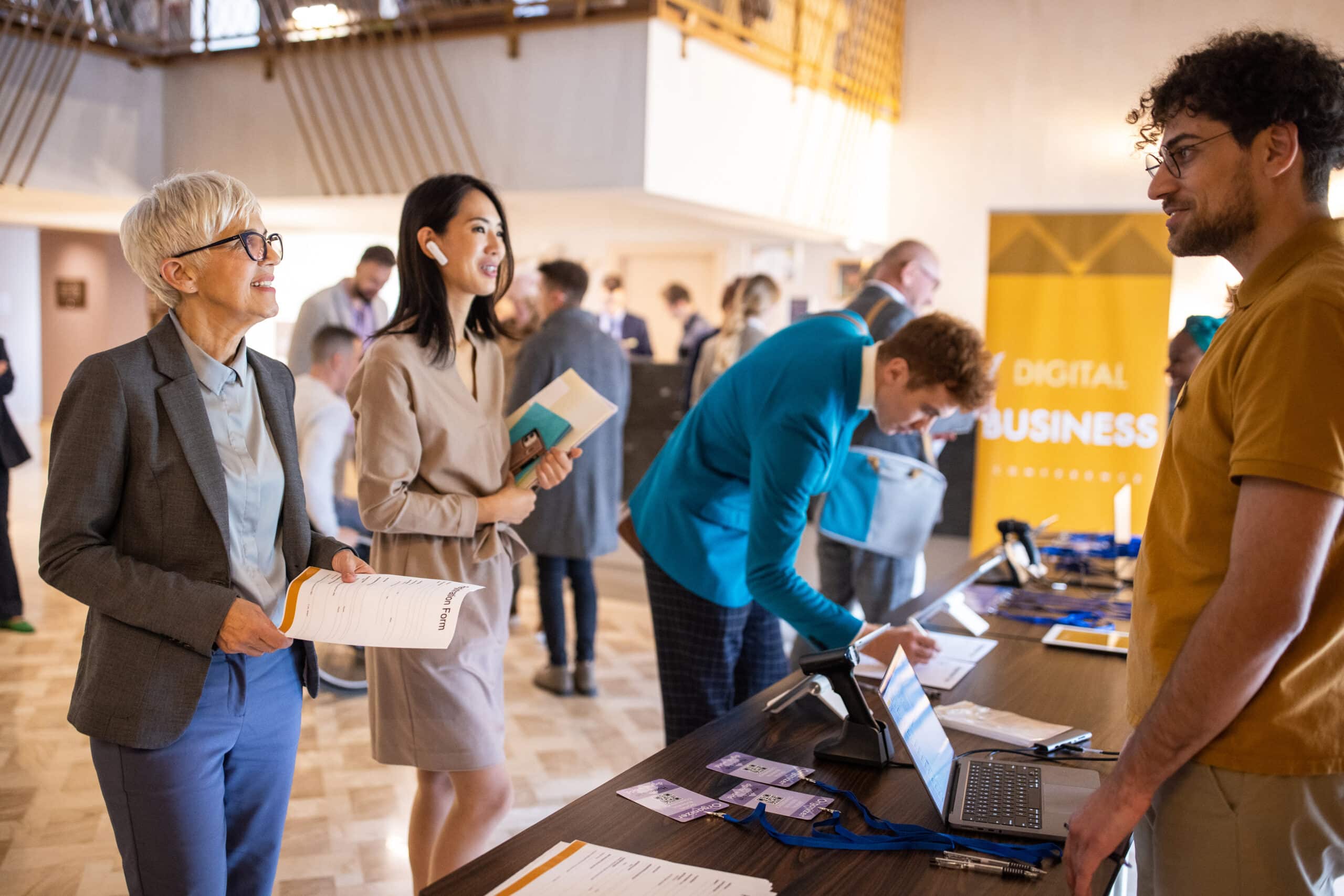 A group of business conference participants registering for a conference in the lobby of a luxury hotel