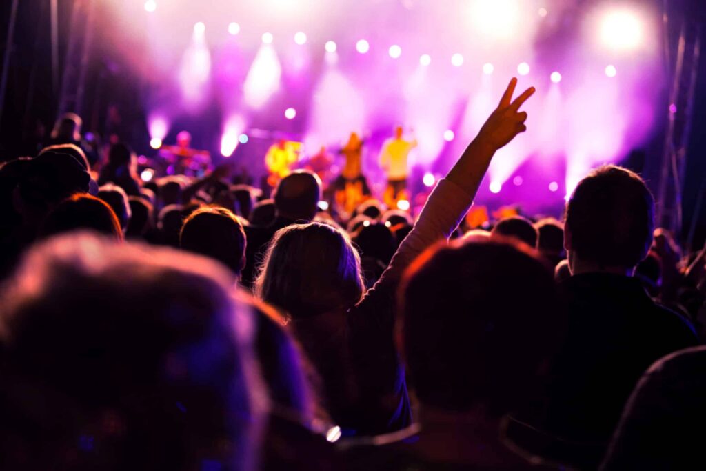 Musical concert with woman giving peace sign with hand